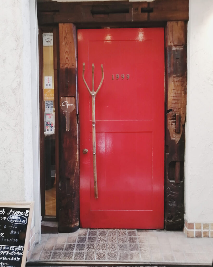 羊の家の入口の赤いドア